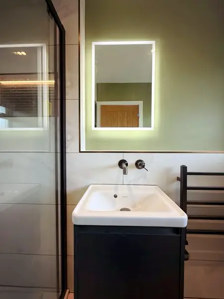 Wall-hung basin with a backlit mirror