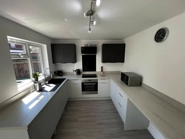 Bright U-shaped kitchen with dark wall units